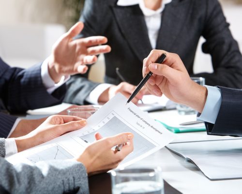 Planning Close-up of businessman explaining a financial plan to colleagues at meeting